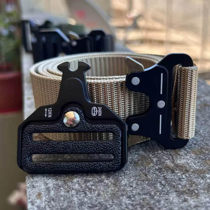 Cinto Tático Militar Defender bege| Fivela Metálica de Engate Rápido, na cor bege cinto esta enrolado encima de uma superfície plana, com a fivela aberta mostrando o mecanismo de encaixe do cinto.