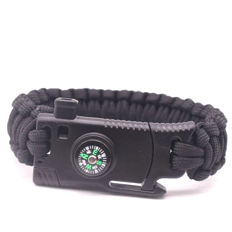 Pulseira de paracord com lâmina, bússola e pederneira da loja arranca toco, ideal para uso tático e aventuras ao ar livre. O design transado das cordas entrelaçadas é destacado em fotografia com fundo branco e iluminação suave, revelando os compartimentos funcionais. A bússola possui roseta verde fluorescente, e a pederneira é discretamente integrado, unindo estilo, praticidade e funcionalidade em um único acessório.